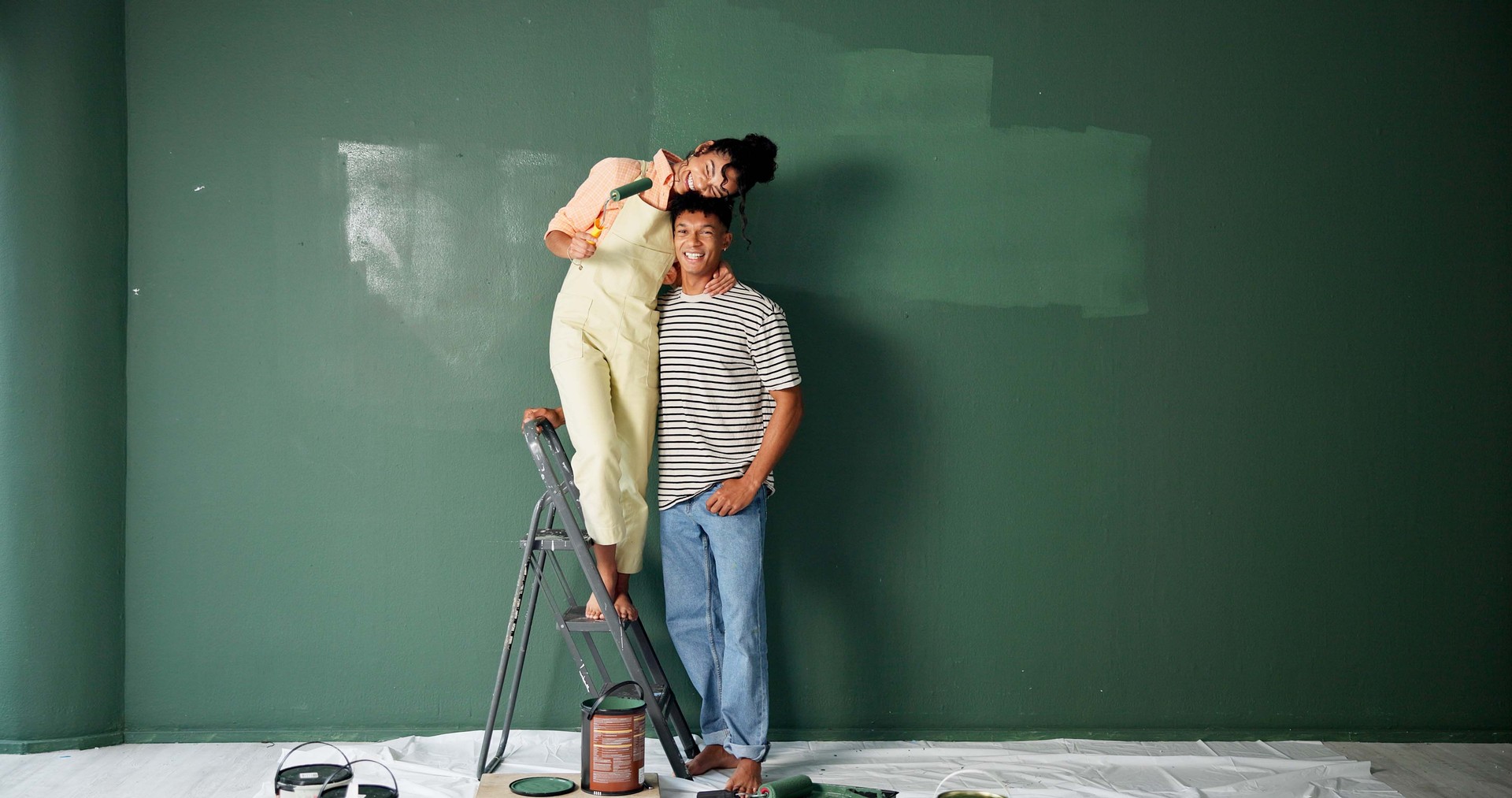 Couple, people and happy with painting wall for house renovations, upgrade and bonding. New home, relationship and smile for makeover for fun with support, care and teamwork for love with space